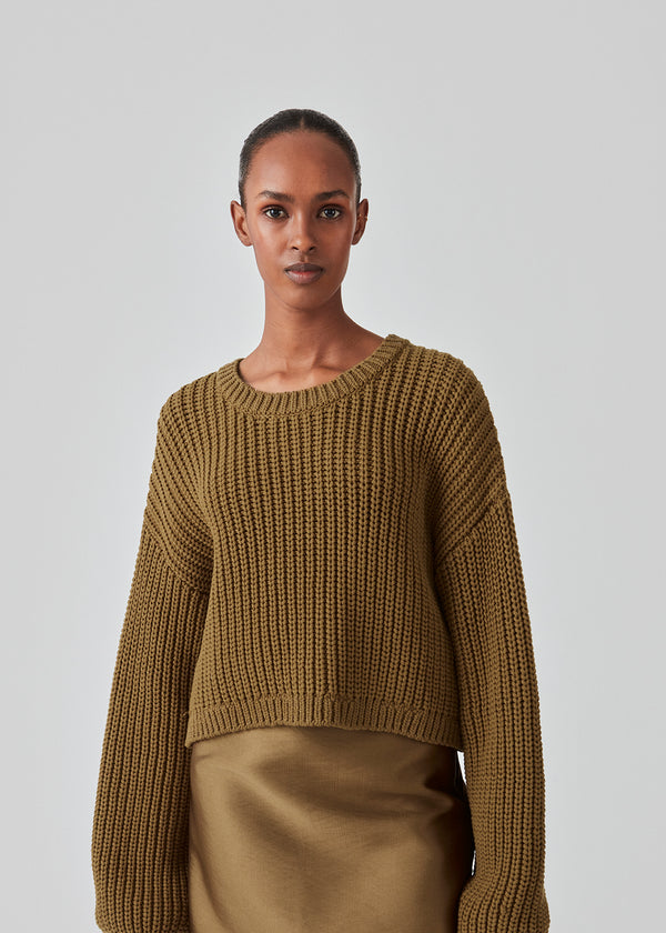 Chunky knit in the color Breen in a cotton blend with a wide, round neck and a slightly cropped length. FlakaMD o-neck has a relaxed silhouette with extra-long balloon sleeves. The model is 175 cm and wears a size S/36.