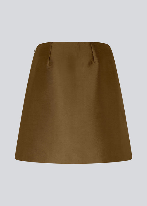 Short skirt made from a heavy, shiny material. FloMD skirt has an A-line silhouette and a hidden zipper at one side. Lined. The model is 175 cm and wears a size S/36.