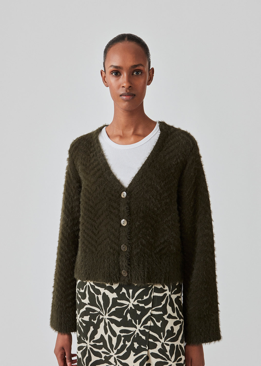 Fluffy cardigan in cotton blend in dark green. FloriaMD cardigan has a rounded shape, v-neckline, long wide sleeves and buttons in front. The model is 175 cm and wears a size S/36.