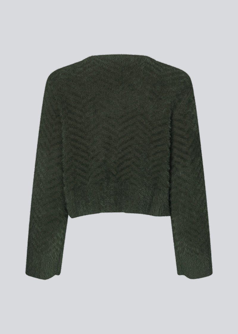 Fluffy cardigan in cotton blend in dark green. FloriaMD cardigan has a rounded shape, v-neckline, long wide sleeves and buttons in front. The model is 175 cm and wears a size S/36.