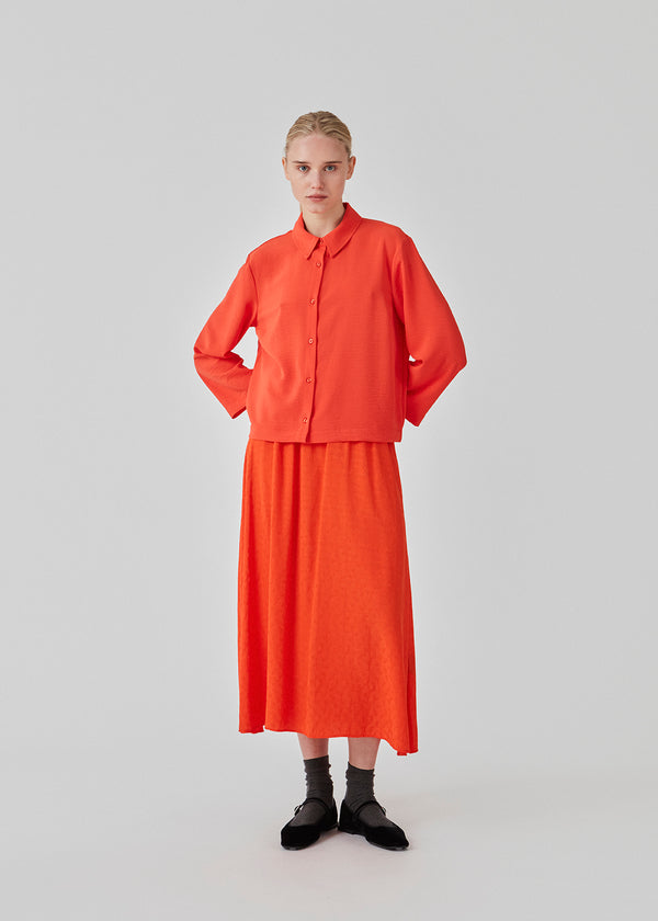 Cropped shirt in bright cherry with a flowy and relaxed fit. FredaMD shirt has a collar and button closure in front, along with 3/4 length wide sleeves. The model is 175 cm and wears a size S/36.