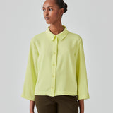 Cropped shirt in light yellow with a flowy and relaxed fit. FredaMD shirt has a collar and button closure in front, along with 3/4 length wide sleeves. The model is 175 cm and wears a size S/36.