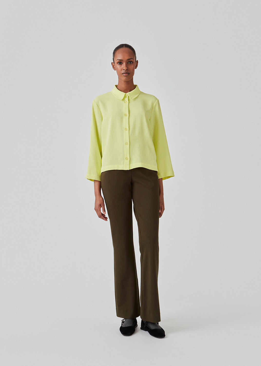 Cropped shirt in light yellow with a flowy and relaxed fit. FredaMD shirt has a collar and button closure in front, along with 3/4 length wide sleeves. The model is 175 cm and wears a size S/36.