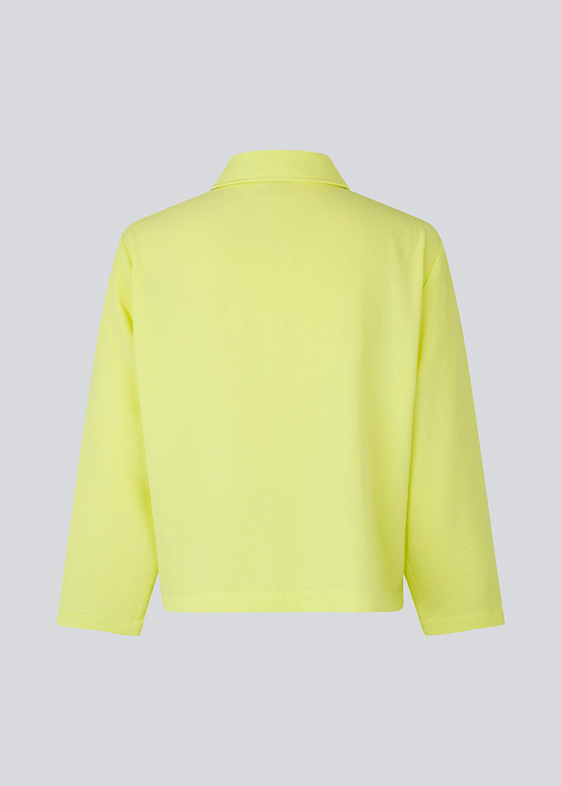 Cropped shirt in light yellow with a flowy and relaxed fit. FredaMD shirt has a collar and button closure in front, along with 3/4 length wide sleeves. The model is 175 cm and wears a size S/36.