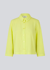 Cropped shirt in light yellow with a flowy and relaxed fit. FredaMD shirt has a collar and button closure in front, along with 3/4 length wide sleeves. The model is 175 cm and wears a size S/36.