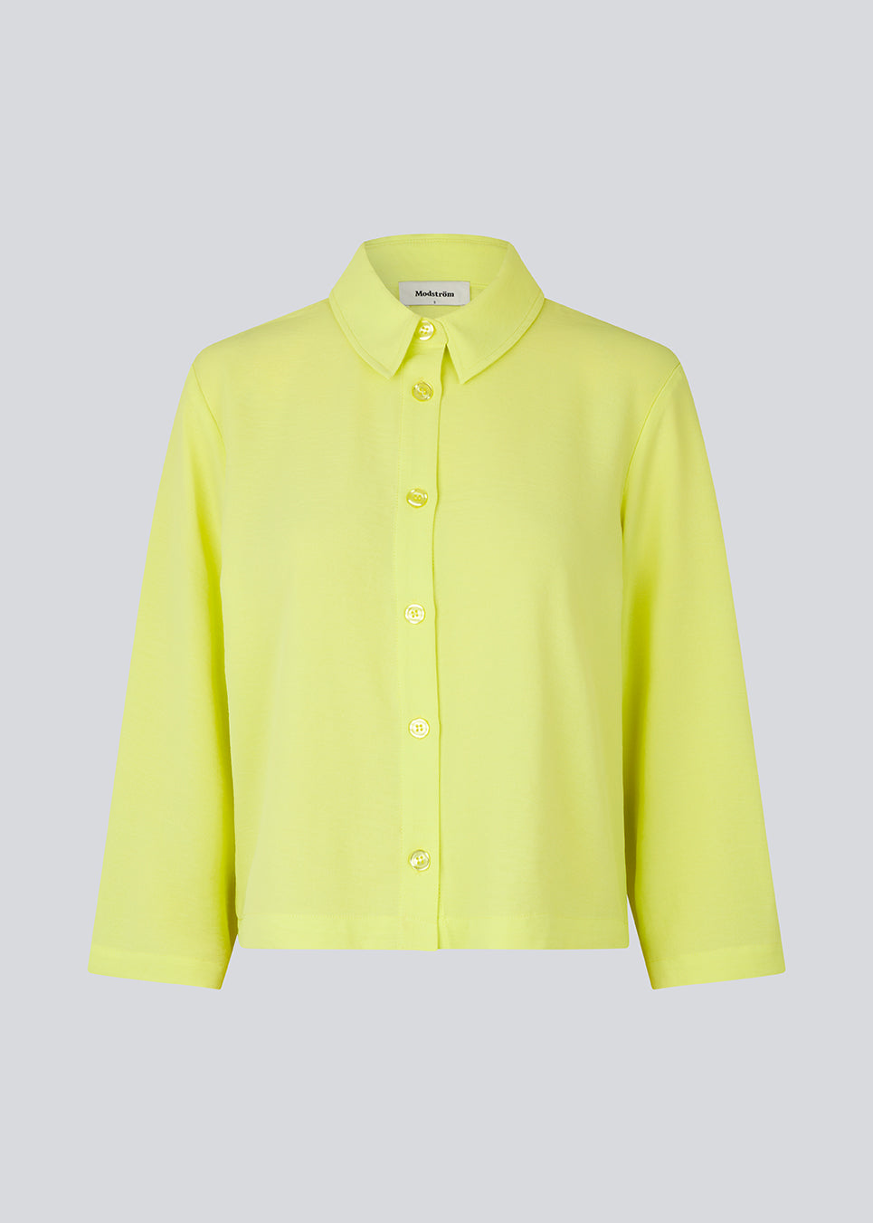 Cropped shirt in light yellow with a flowy and relaxed fit. FredaMD shirt has a collar and button closure in front, along with 3/4 length wide sleeves. The model is 175 cm and wears a size S/36.