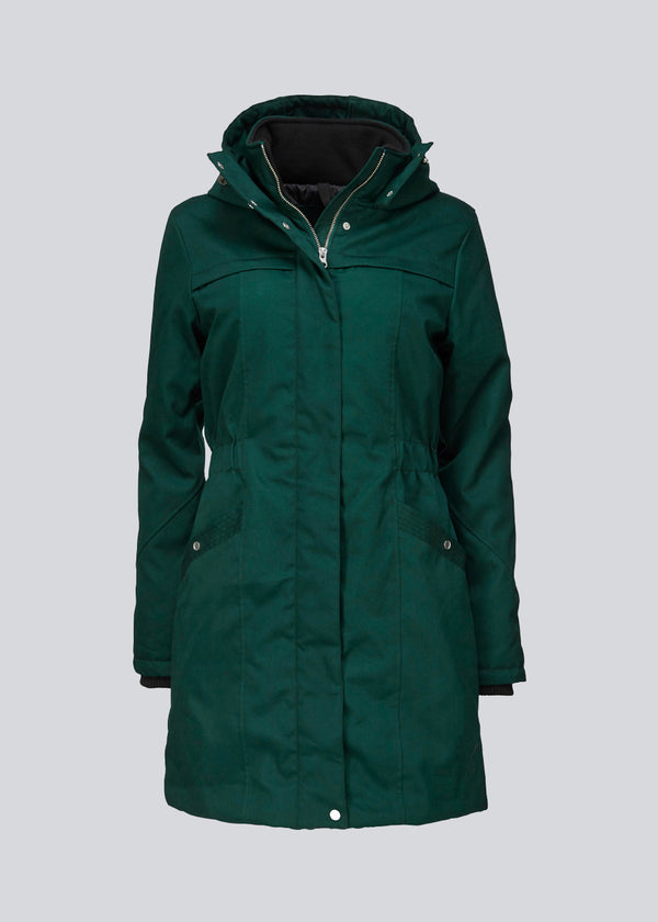 Green jacket. Frida has a hoodie, is knee-length and has an invisible button/zipper closure. The jacket has a tight fit, which gives a feminine look. The padding is M3 Thinsulate, which is recognized for its high insulation ability and is, therefore, the perfect choice.