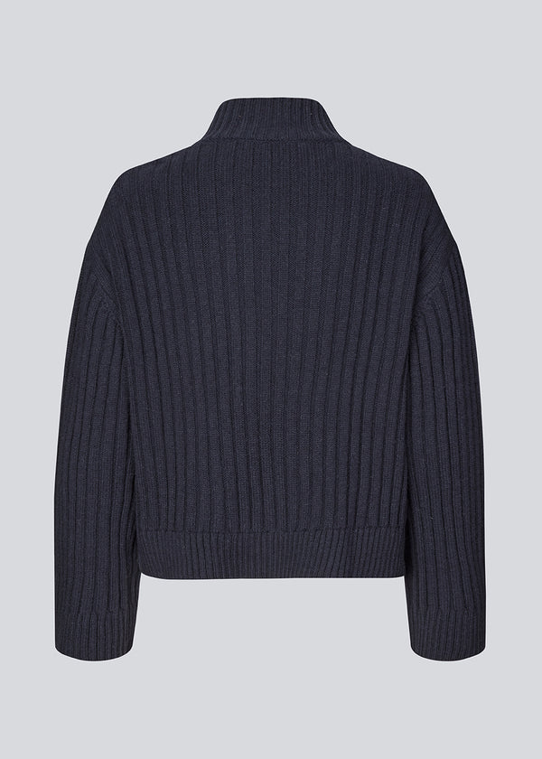 Rib knitted jumper in a navy color with a high neck and a relaxed fit. FultonMD rib t-neck has dropped shoulders and long wide sleeves.