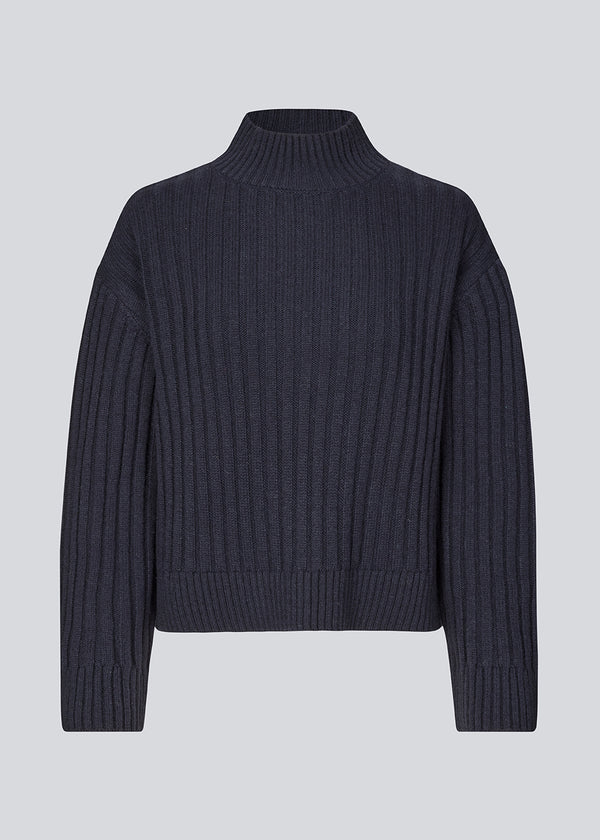 Rib knitted jumper in a navy color with a high neck and a relaxed fit. FultonMD rib t-neck has dropped shoulders and long wide sleeves.