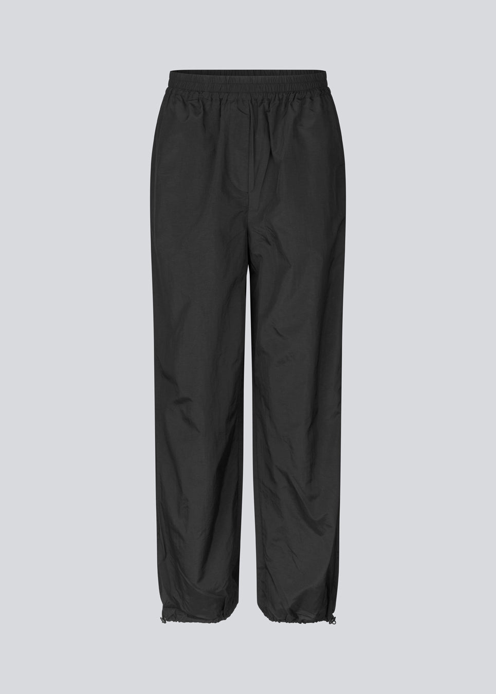 Parachute black pants in nylon with a relaxed fit. FumikoMD pants have a regular waist with elastic, wide legs and elastic drawstring at the waist. 