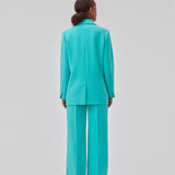 Gale pants in turquoise have a classic design. The pants have straight, wide legs with press folds, which creates an elegant look. The model is 175 cm and wears a size S/36.  Shop matching blazer: Gale blazer.