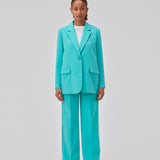 Gale pants in turquoise have a classic design. The pants have straight, wide legs with press folds, which creates an elegant look. The model is 175 cm and wears a size S/36.  Shop matching blazer: Gale blazer.
