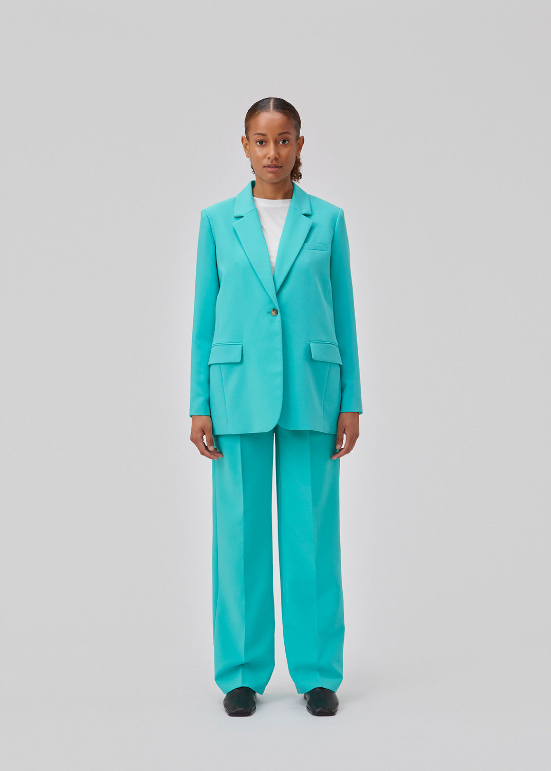 Gale pants in turquoise have a classic design. The pants have straight, wide legs with press folds, which creates an elegant look. The model is 175 cm and wears a size S/36.  Shop matching blazer: Gale blazer.