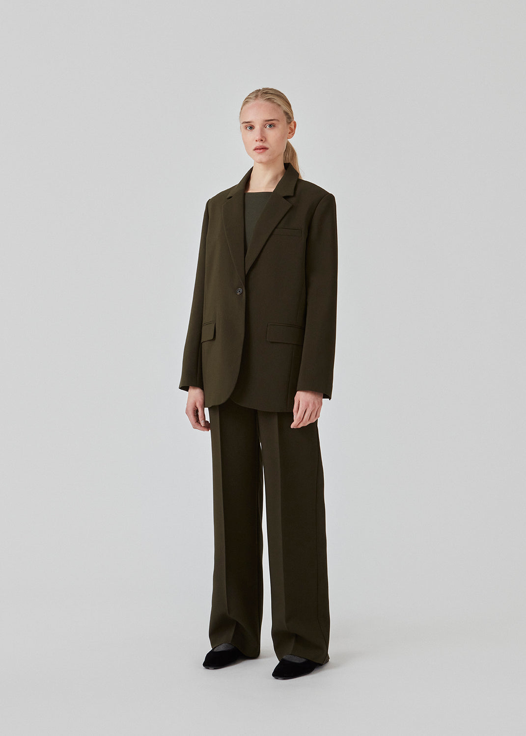 Gale pants have a classic design in dark green. The pants have straight, wide legs with press folds, which creates an elegant look. The model is 175 cm and wears a size S/36.  Style the pants with matching blazer in the same color: Gale blazer.