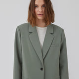 Gale blazer in soft green has a classic and elegant design, fulfilled by the beautiful revers collar and a long fit. The blazer has button closure at the front and a chest pocket at the left side. The model is 175 cm and wears a size S/36.