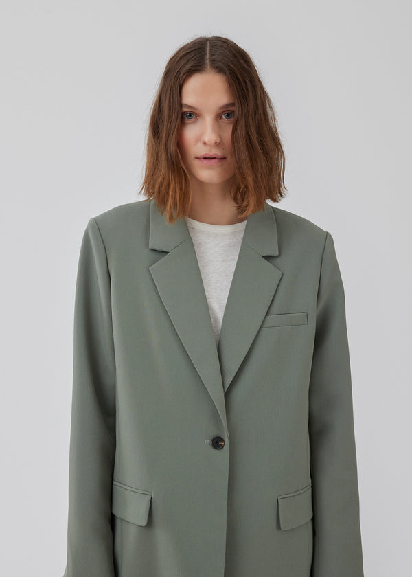 Gale blazer in soft green has a classic and elegant design, fulfilled by the beautiful revers collar and a long fit. The blazer has button closure at the front and a chest pocket at the left side. The model is 175 cm and wears a size S/36.