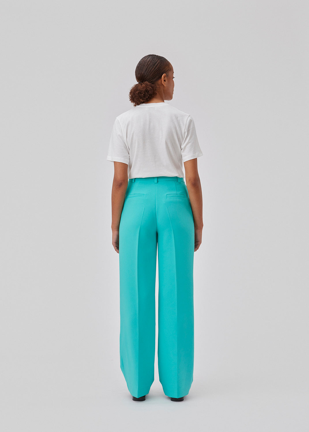 Gale pants in turquoise have a classic design. The pants have straight, wide legs with press folds, which creates an elegant look. The model is 175 cm and wears a size S/36.  Shop matching blazer: Gale blazer.