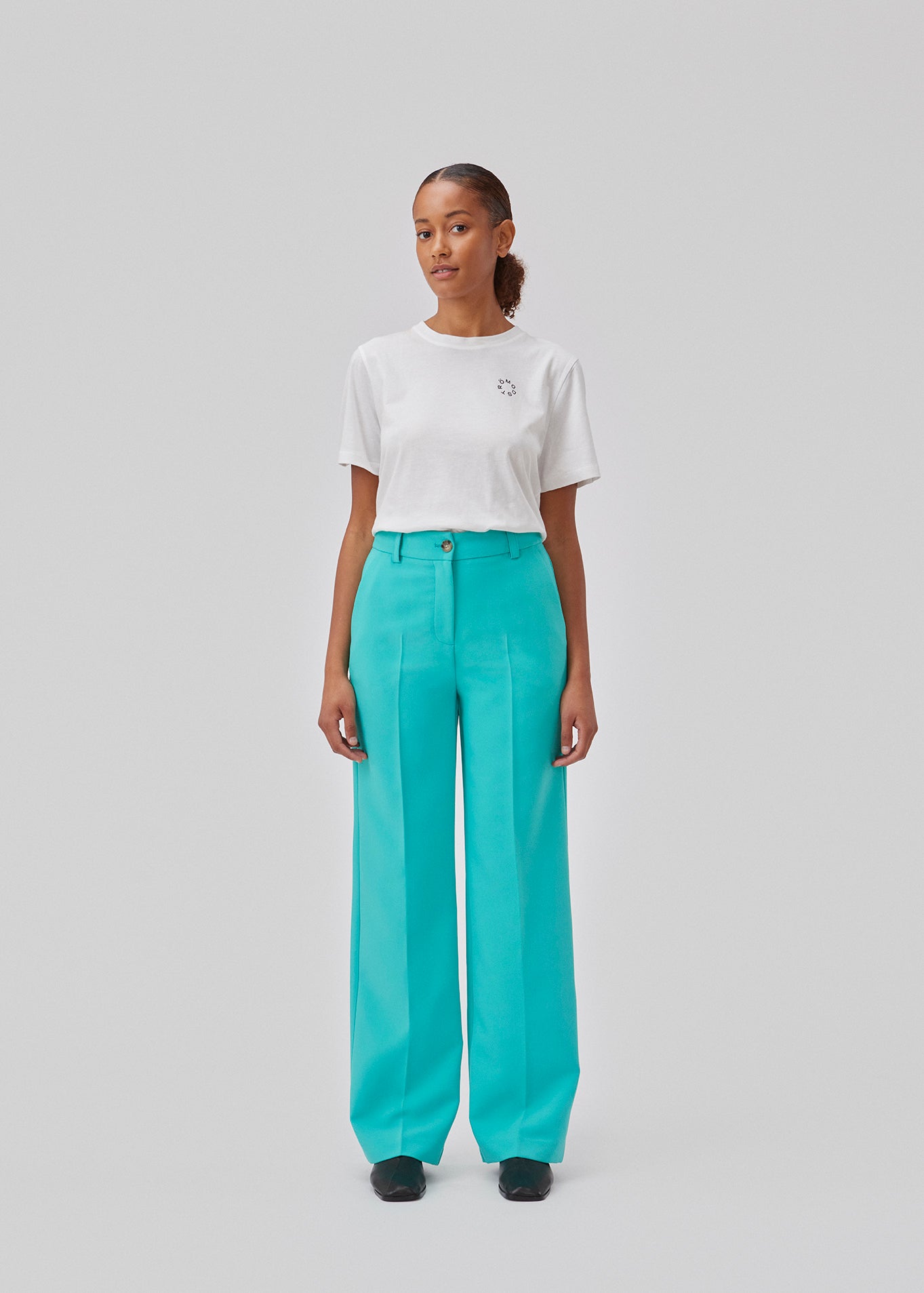 Gale pants in turquoise have a classic design. The pants have straight, wide legs with press folds, which creates an elegant look. The model is 175 cm and wears a size S/36.  Shop matching blazer: Gale blazer.