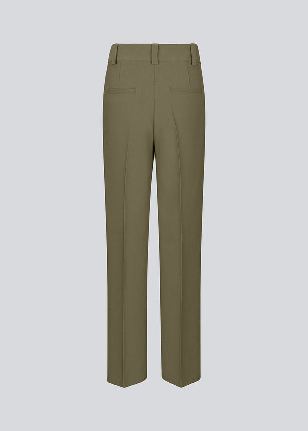 Gale pants in a dark green color with a classic design. The pants has straight, wide legs with pressfolds, which creates an elegant look.