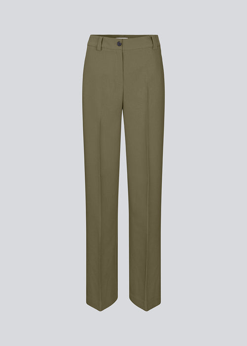 Gale pants in a dark green color with a classic design. The pants has straight, wide legs with pressfolds, which creates an elegant look.