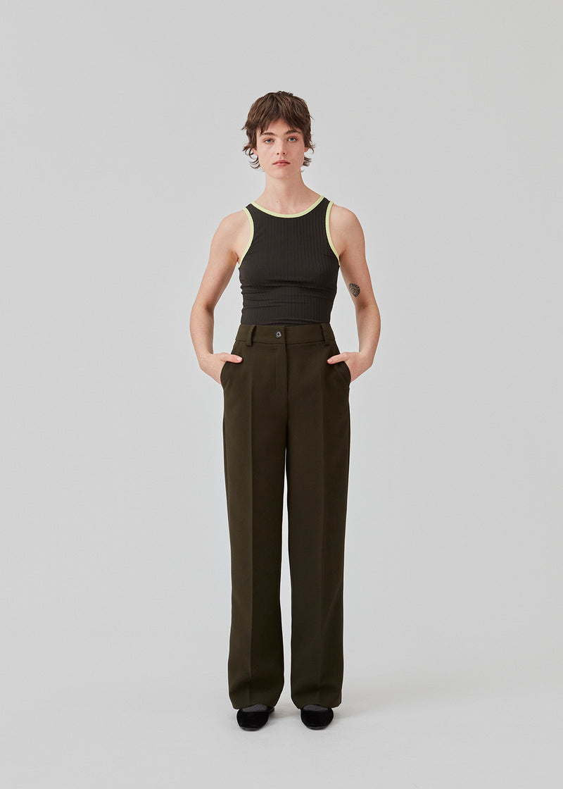 Gale pants have a classic design in dark green. The pants have straight, wide legs with press folds, which creates an elegant look. The model is 175 cm and wears a size S/36.  Style the pants with matching blazer in the same color: Gale blazer.