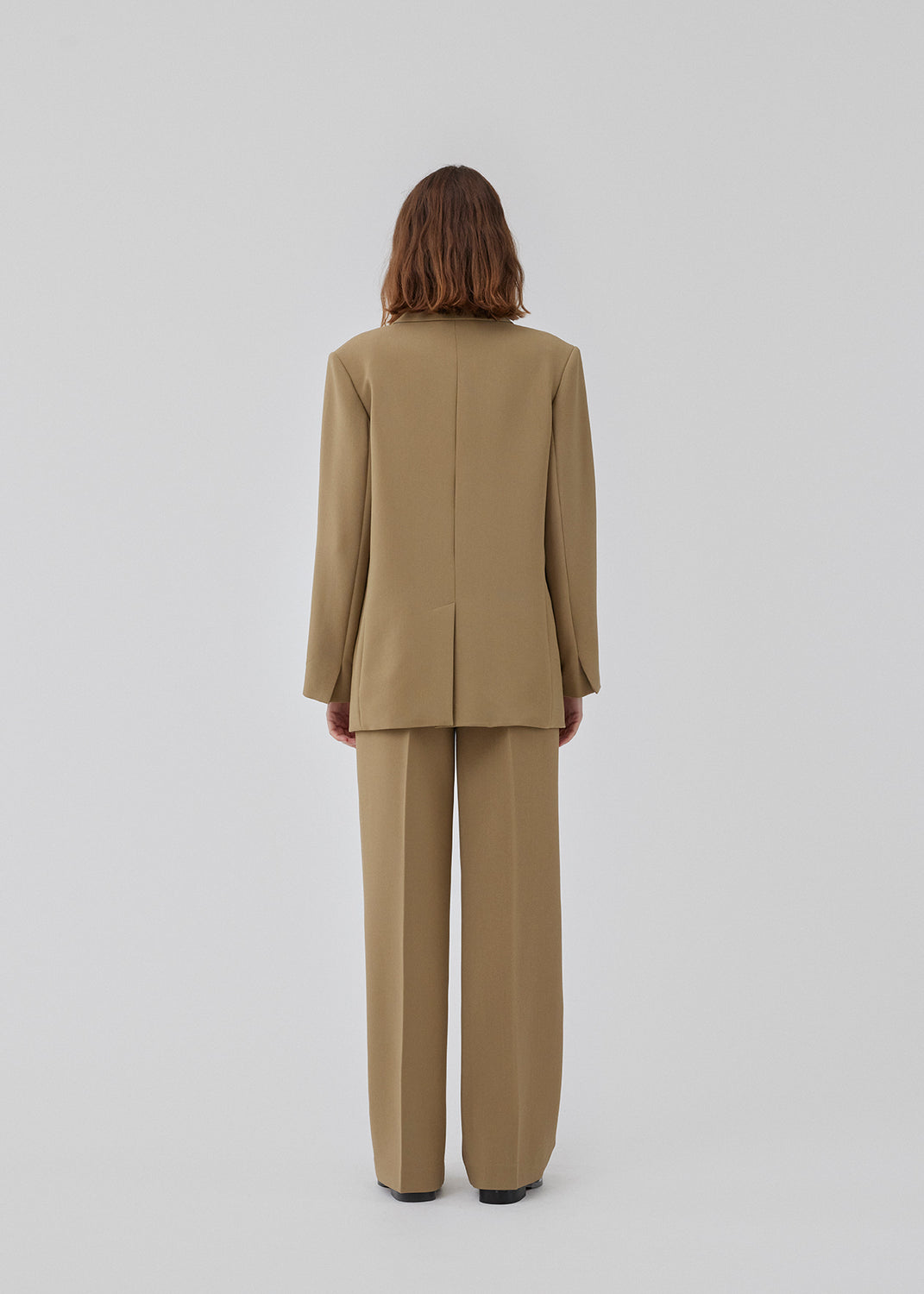 Gale pants in the color Dune have a classic design. The pants have straight, wide legs with press folds, which creates an elegant look. The model is 177 cm and wears a size S/36.