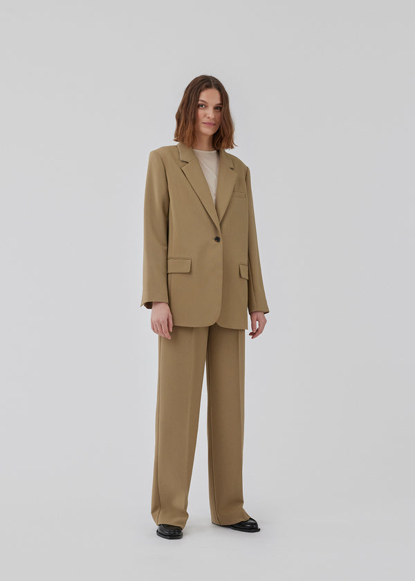 Gale pants in the color Dune have a classic design. The pants have straight, wide legs with press folds, which creates an elegant look. The model is 177 cm and wears a size S/36.