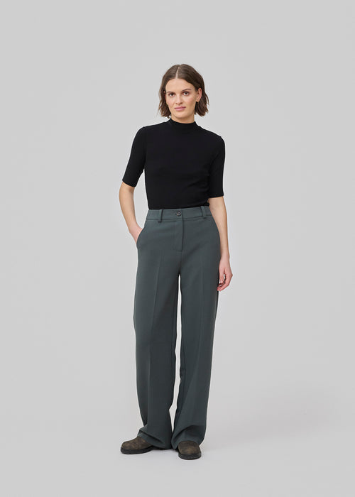 Gale pants has a classic design. The pants has straight, wide legs with pressfolds, which creates an elegant look. The model is 175 cm and wears a size S/36.