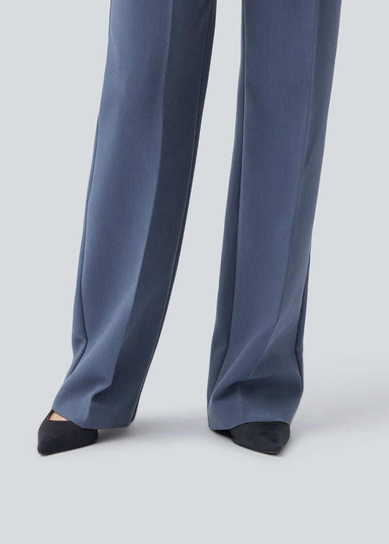 Gale pants has a classic design. The pants has straight, wide legs with pressfolds, which creates an elegant look. The model is 175 cm and wears a size S/36.