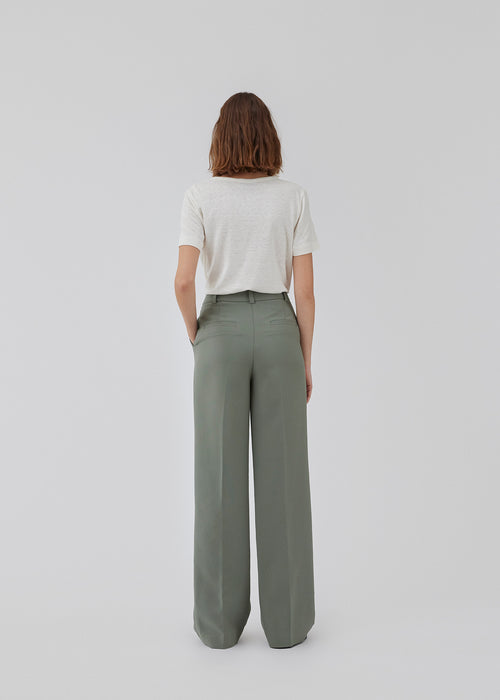 Gale pants in soft green has a classic design. The pants has straight, wide legs with pressfolds, which creates an elegant look. The model is 175 cm and wears a size S/36.<br>