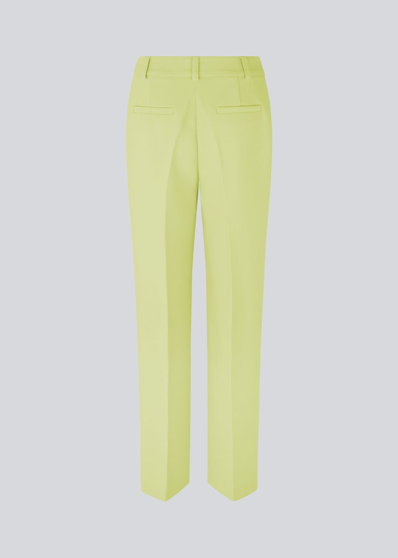 Gale pants in yellow have a classic design. The pants have straight, wide legs with press folds, which creates an elegant look.  The model is 177 cm and wears a size S/36.