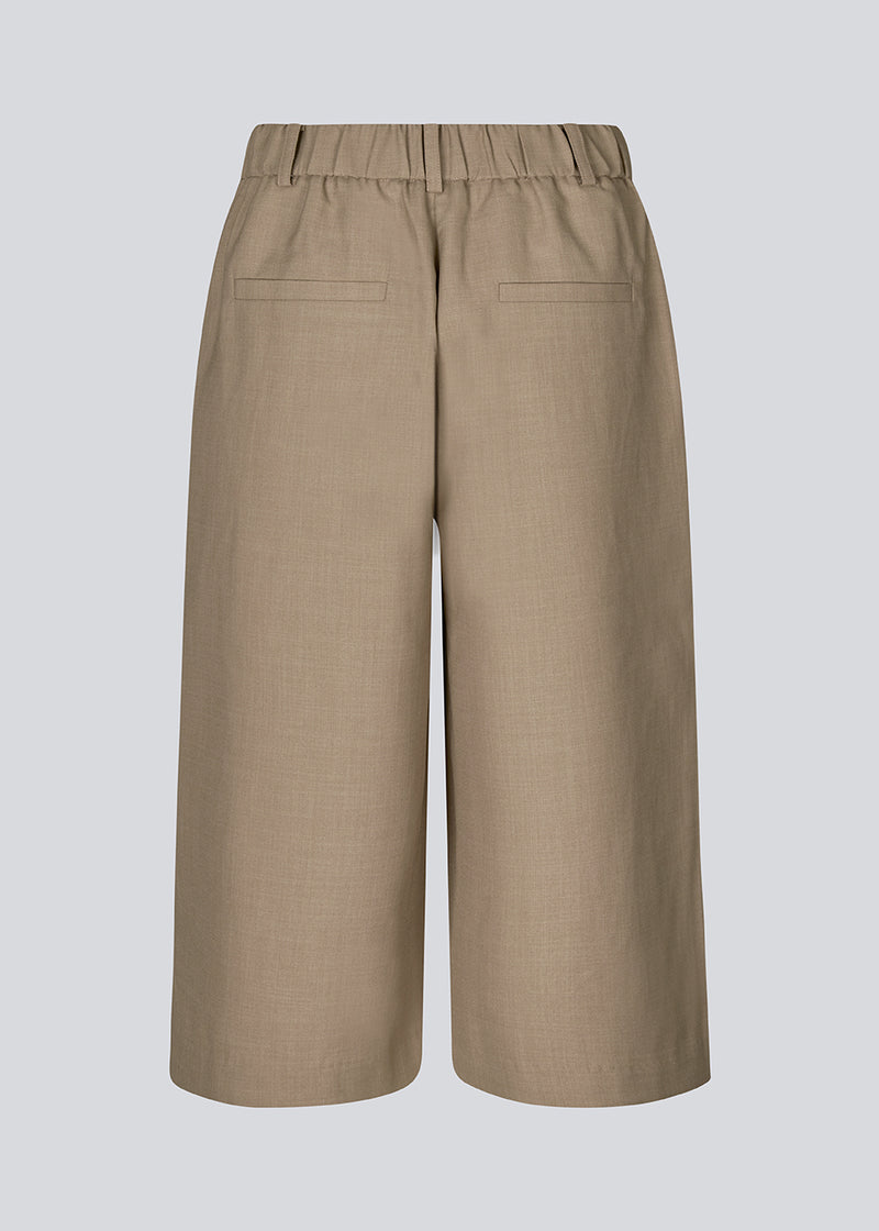 Long shorts in brown with pleats. Galemd 2 long shorts have an elastic waist, fly and side pockets. Perfect light fabric for the summer weather.