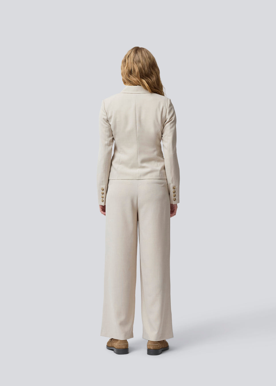 GaleMD 2 short blazer features the classic Gale design but in a lighter quality. The blazer is fitted, slightly cropped, and has a button closure and two pockets in front. The blazer is light cream.