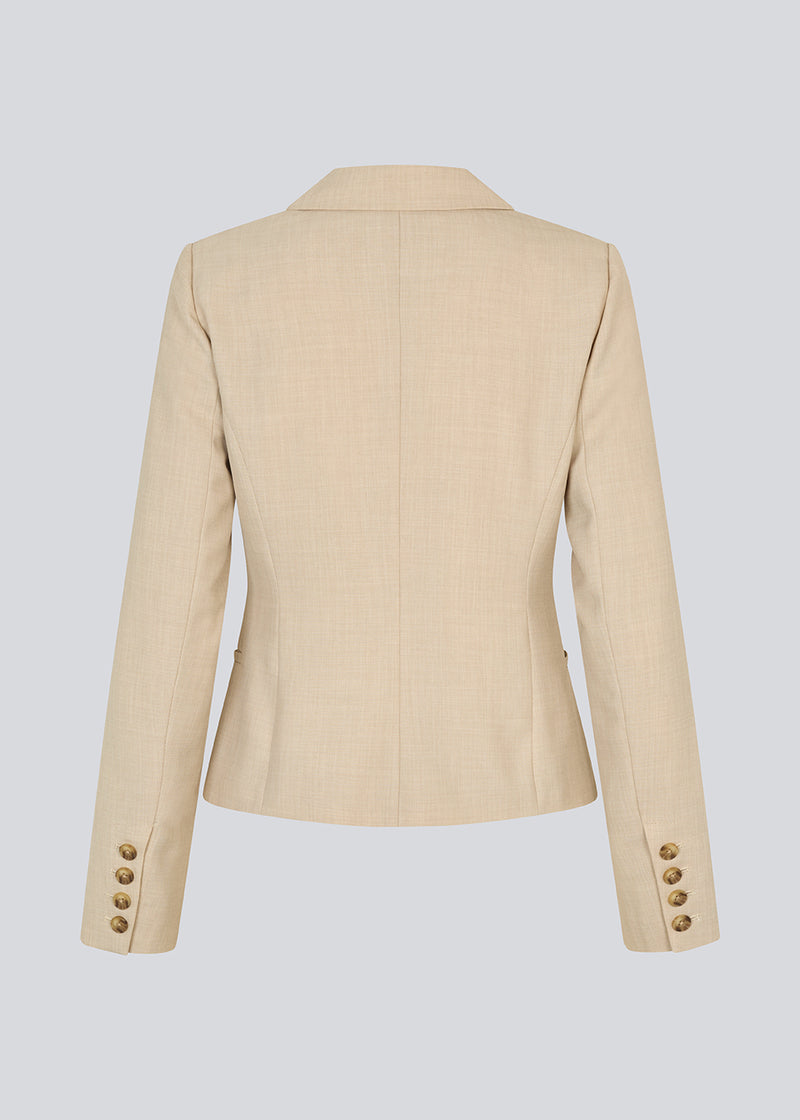 GaleMD 2 short blazer features the classic Gale design but in a lighter quality. The blazer is fitted, slightly cropped, and has a button closure and two pockets in front. The blazer is light cream.
