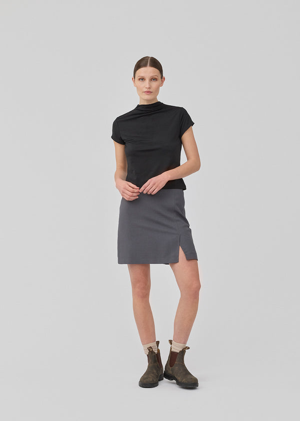 Classic A-line skirt in grey with a short length. GaleMD 2 skirt has a simple design with a hidden zipper at the side seam and a slit in front. The model is 175 cm and wears a size S/36.