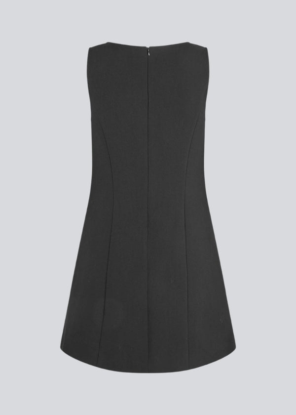 Sleeveless black dress in the classic gale material. GaleMD flare dress is fitted and has an invisible zipper in the back. The model is 177 cm and wears a size S/36.