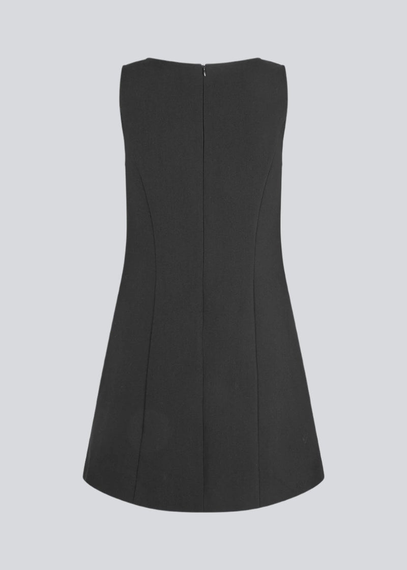 Sleeveless black dress in the classic gale material. GaleMD flare dress is fitted and has an invisible zipper in the back. The model is 177 cm and wears a size S/36.