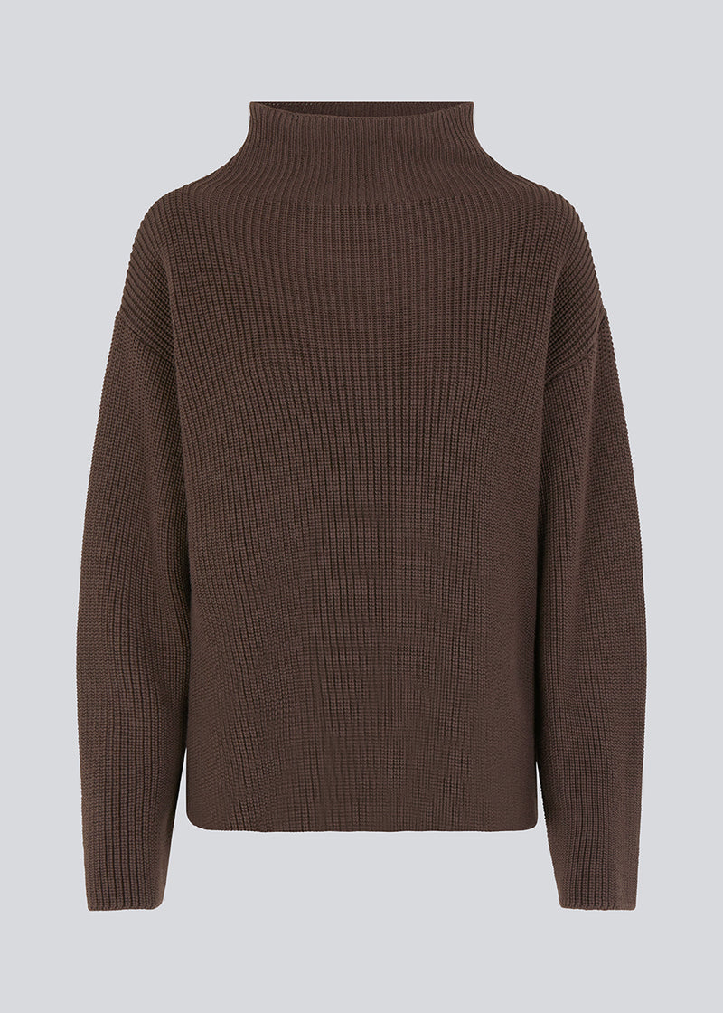 GalenMD t-neck in brown knitted from organic cotton with an oversized shape, lange and wide sleeves, along with a high neck and dropped shoulders. The model is 175 cm and wears a size S/36.