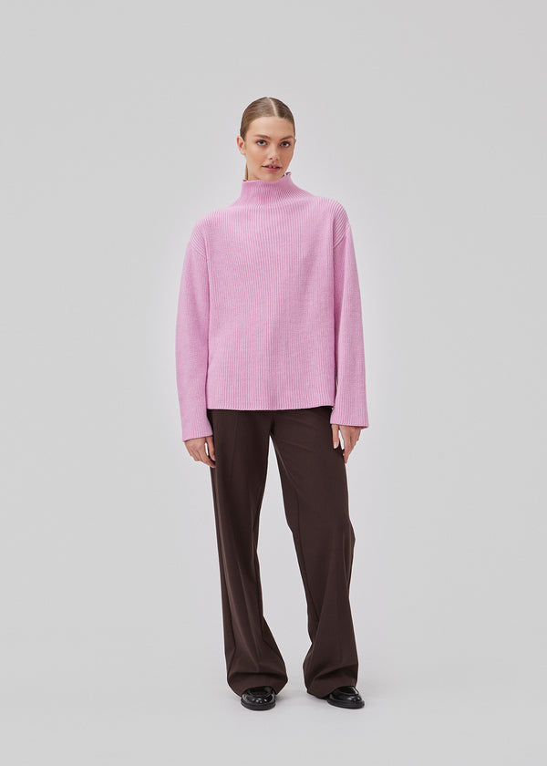 GalenMD t-neck in pastel lavender knitted from organic cotton with an oversized shape, lange and wide sleeves, along with a high neck and dropped shoulders. The model is 175 cm and wears a size S/36.