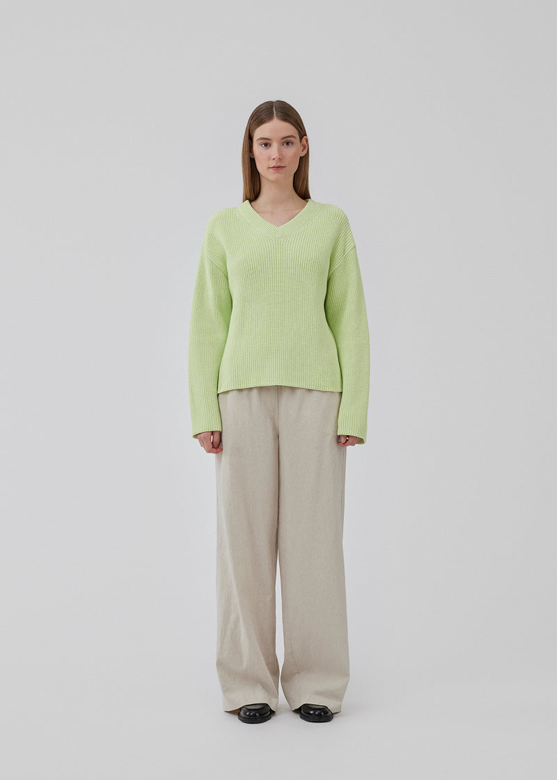 GalenMD v-neck in bright greenis knitted from an organic cotton with an oversize fit, long wide sleeves, a v-neck, and dropped shoulders. The model is 175 cm and wears a size S/36.<br>