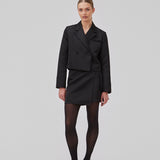 Cropped double-breasted blazer in a heavy satin. GavinMD blazer has a collar and lapels, fabric covered buttons in front and slits at cuffs. The model is 175 cm and wears a size S/36