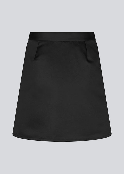 Wrap skirt in mini length. GavinMD skirt is made in a heavy satin with a wrap effect in front, closed with a wide belt and D-ring. The model is 175 cm and wears a size S/36.