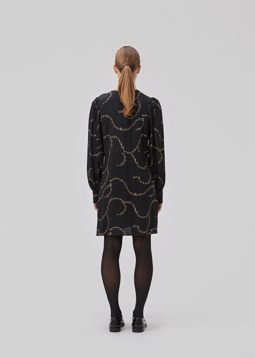 Short dress with a v-shaped neckline and buttons in front. GelilaMD print dress has long balloon sleeves with a wide cuff. The model is 175 cm and wears a size S/36.