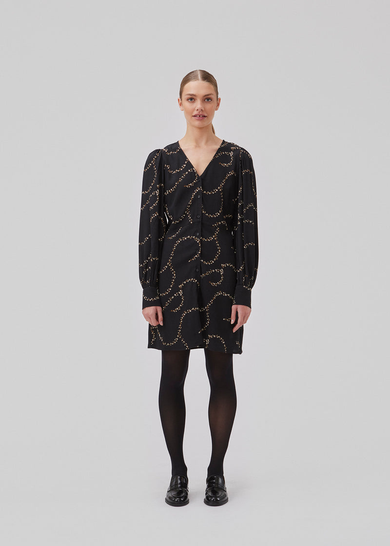 Short dress with a v-shaped neckline and buttons in front. GelilaMD print dress has long balloon sleeves with a wide cuff. The model is 175 cm and wears a size S/36.