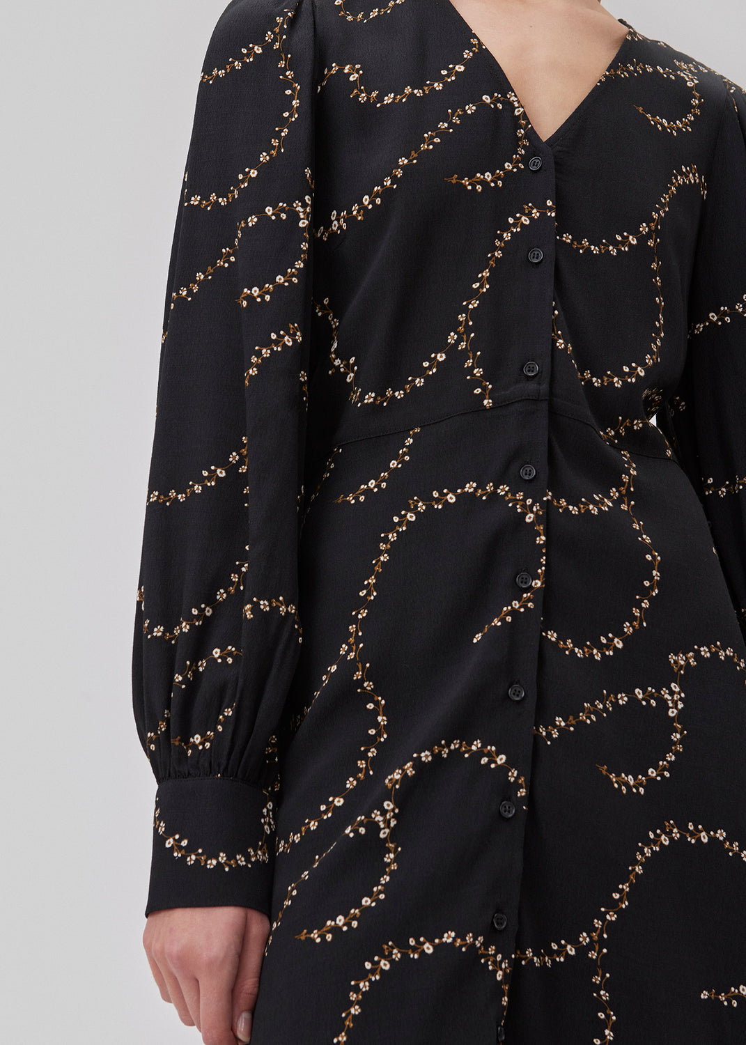 Short dress with a v-shaped neckline and buttons in front. GelilaMD print dress has long balloon sleeves with a wide cuff. The model is 175 cm and wears a size S/36.