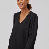 Black dress with a loose silhouette in a structured material. GemmiMD dress has long, voluminous balloon sleeves with cuff and a v-neckline. The model is 175 cm and wears a size S/36.