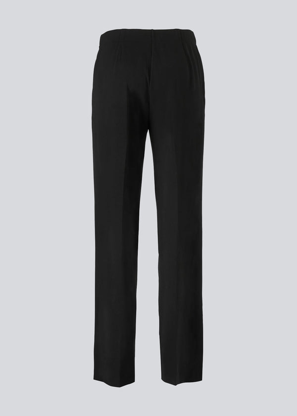 Classic pants with elastic at the waist and pressfolds. Gene pants has pockets at the side and straight, wide legs.