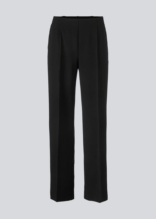 Classic pants with elastic at the waist and pressfolds. Gene pants has pockets at the side and straight, wide legs.