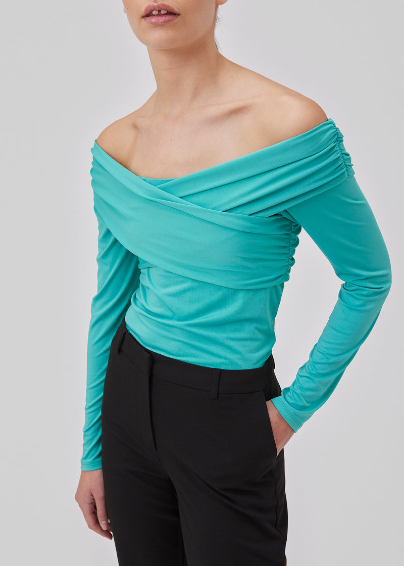 Long-sleeved top in turquoise in a soft quality. GeorgiaMD wrap top has a slim silhouette and a slight off-shoulder-effect with a draped wrap look at the top. The model is 175 cm and wears a size S/36.