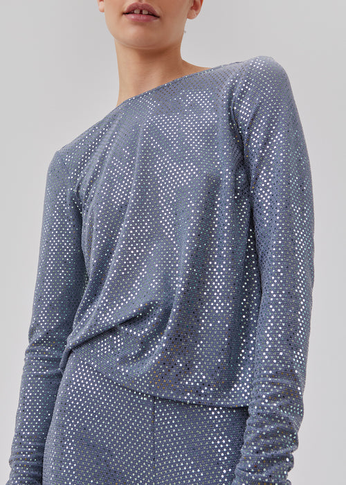 GiaMD top has a slim silhouette with a round neck and long sleeves. The top is detailed with sequins and a large opening in the back. The model is 175 cm and wears a size S/36.